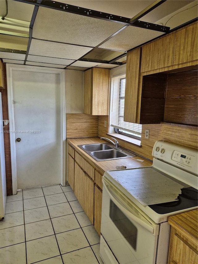 kitchen featuring light tile patterned flooring, white appliances, and sink