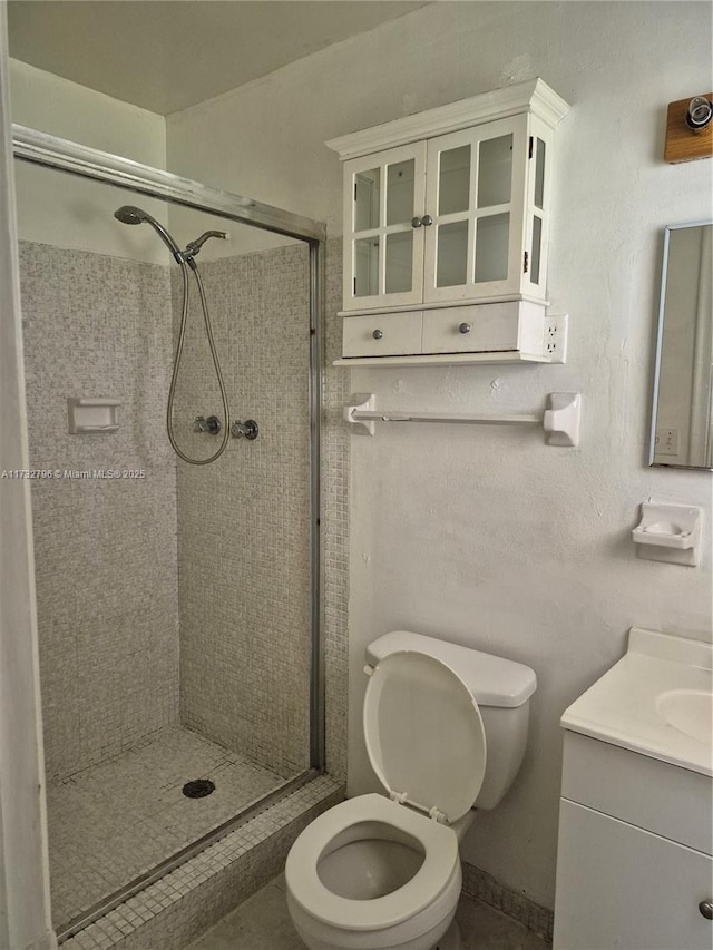 bathroom with walk in shower, vanity, and toilet