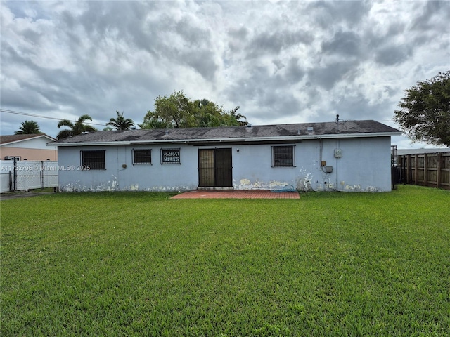 back of house featuring a lawn