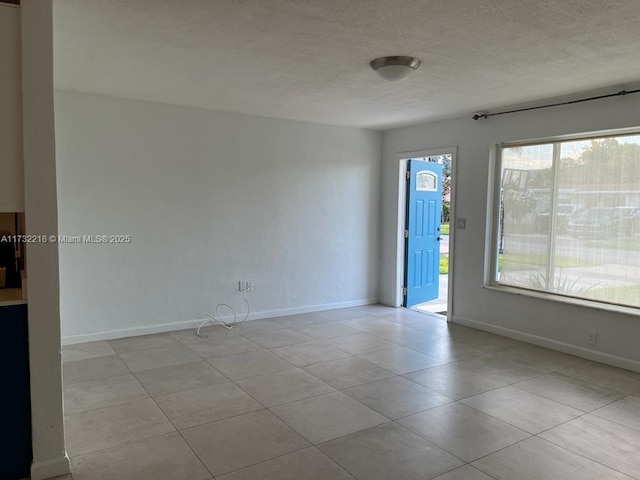 empty room with a healthy amount of sunlight and light tile patterned floors