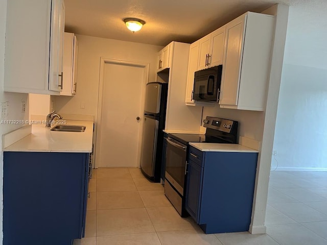 kitchen featuring sink, blue cabinetry, appliances with stainless steel finishes, white cabinetry, and light tile patterned flooring