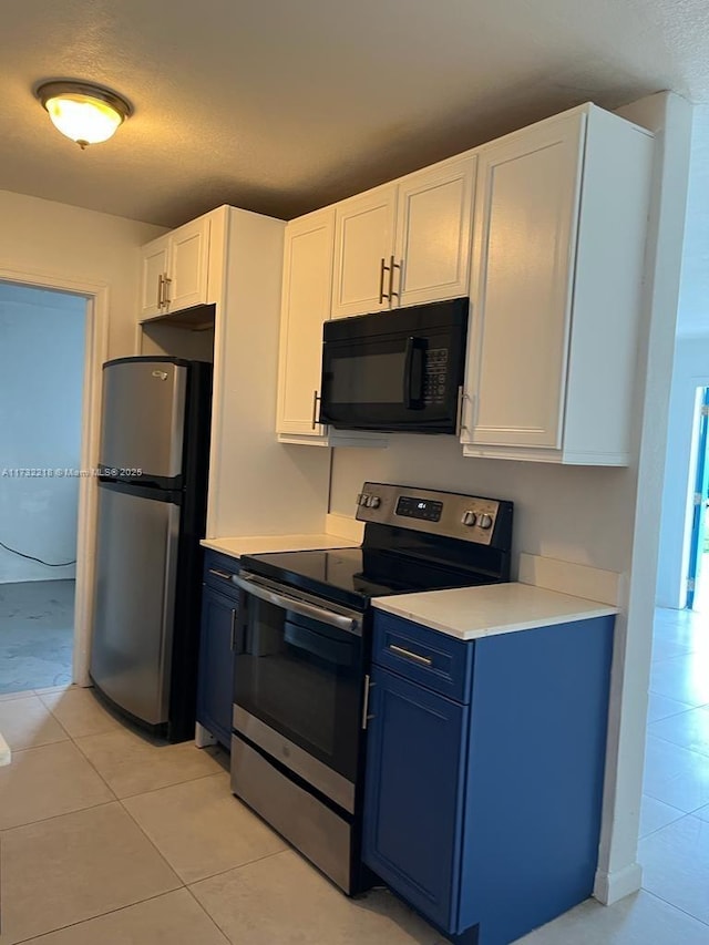 kitchen featuring white cabinetry, appliances with stainless steel finishes, blue cabinetry, and light tile patterned floors