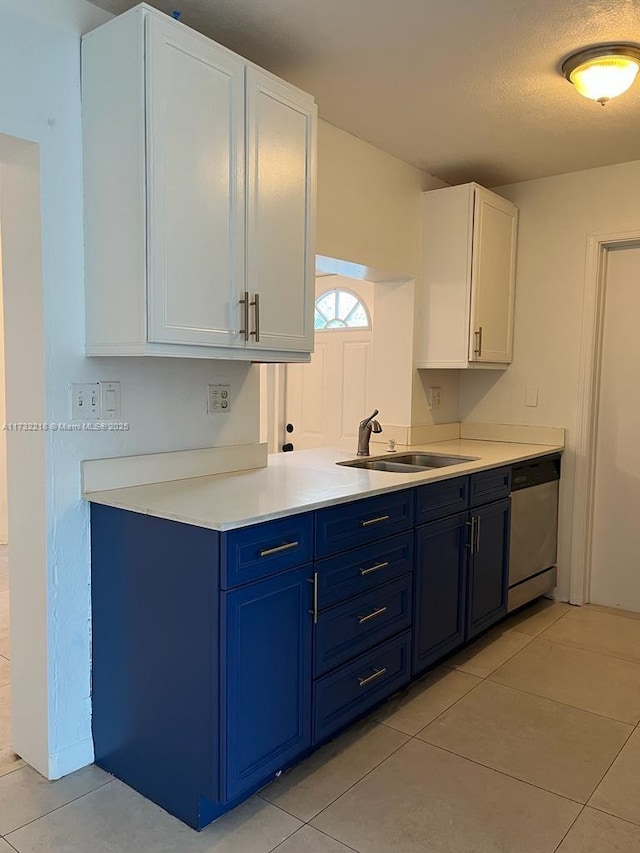 kitchen featuring sink, light tile patterned floors, dishwasher, white cabinetry, and blue cabinets