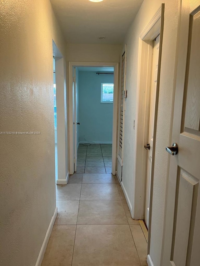 hall with light tile patterned floors