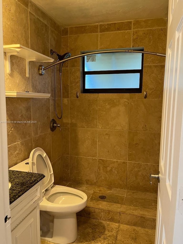 bathroom featuring tiled shower, vanity, and toilet