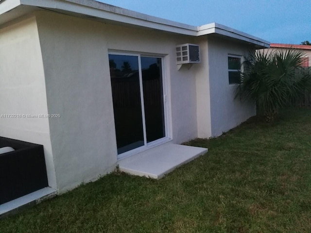 view of side of home with a lawn and a wall unit AC