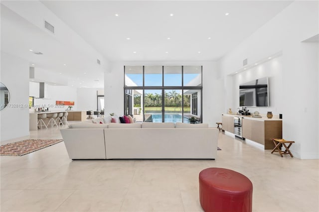 living room with floor to ceiling windows, a high ceiling, and light tile patterned floors