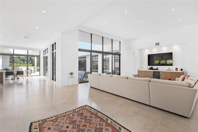 living room with expansive windows, beverage cooler, and light tile patterned floors