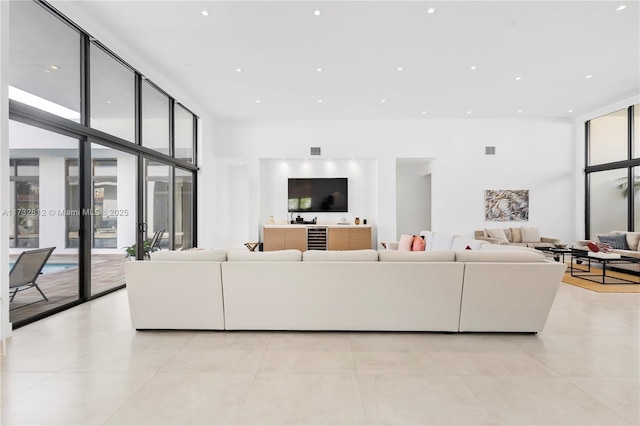 tiled living room featuring expansive windows and a high ceiling