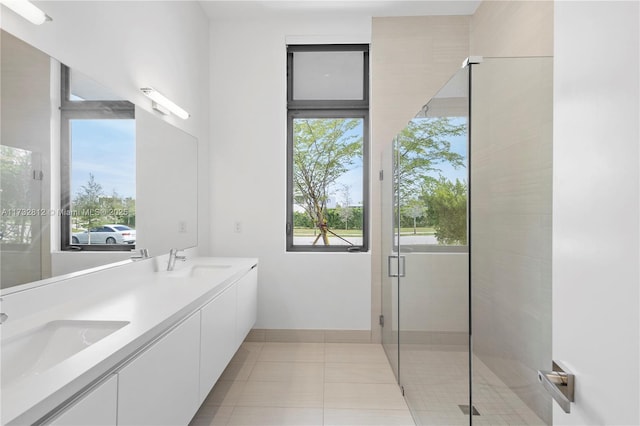 bathroom featuring a shower with door, vanity, a wealth of natural light, and tile patterned floors