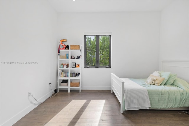 bedroom with dark hardwood / wood-style floors