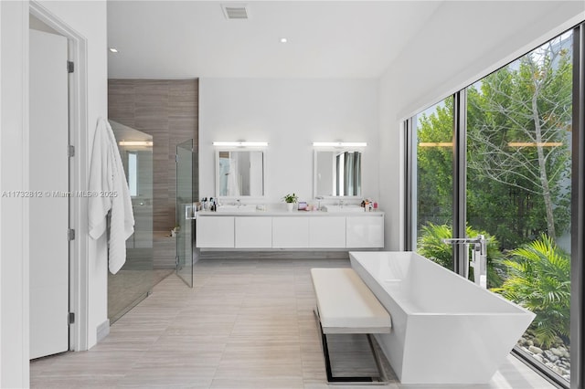 bathroom featuring tile patterned floors, vanity, and separate shower and tub