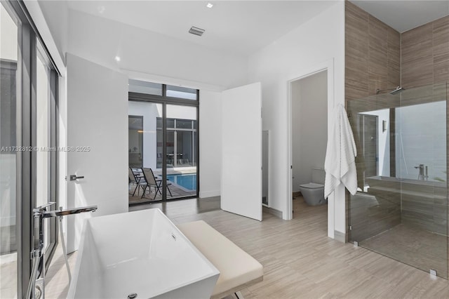 bathroom featuring separate shower and tub and toilet