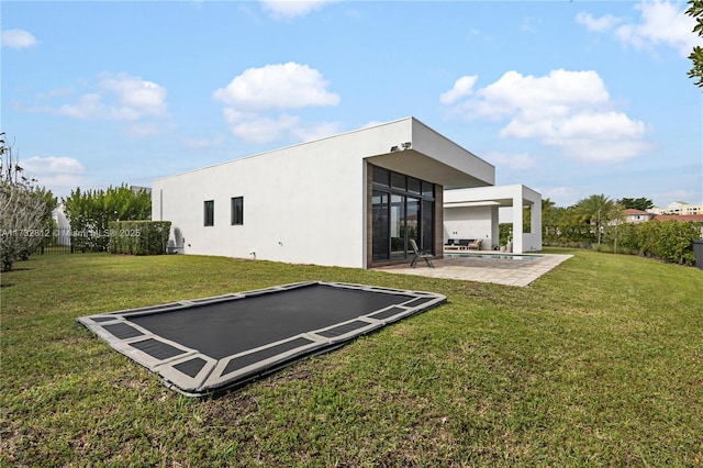 rear view of property featuring a patio and a yard