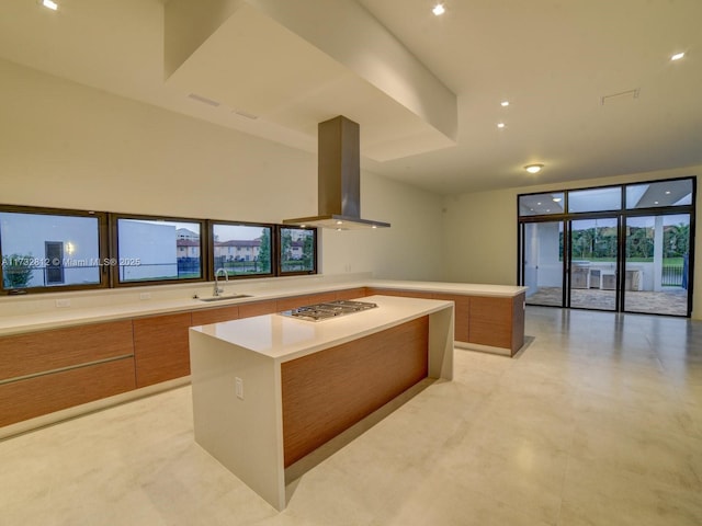 kitchen with island exhaust hood, sink, a kitchen island, and stainless steel gas cooktop