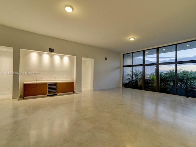 interior space with floor to ceiling windows, beverage cooler, and indoor wet bar