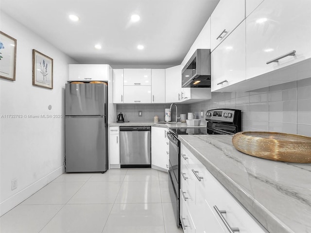 kitchen with sink, appliances with stainless steel finishes, white cabinetry, backsplash, and light stone counters