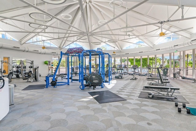 exercise room with high vaulted ceiling and ceiling fan