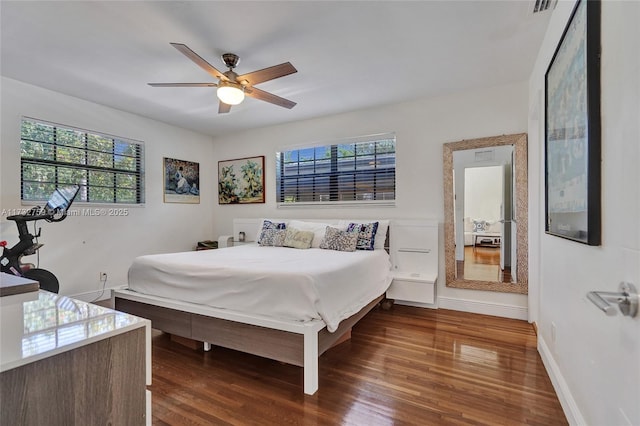 bedroom with dark hardwood / wood-style floors and ceiling fan