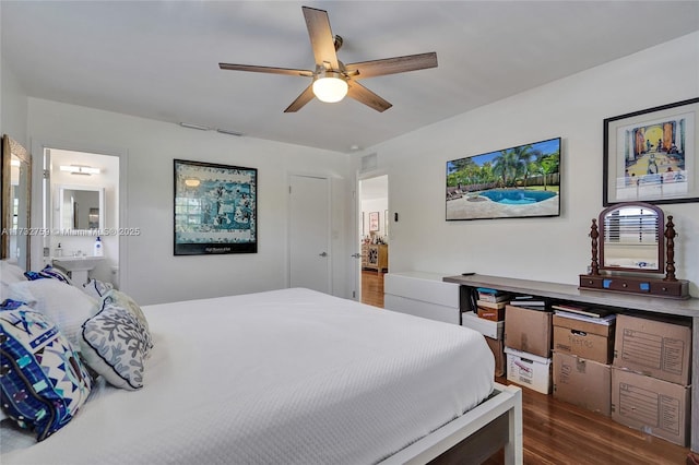 bedroom featuring dark hardwood / wood-style flooring, ensuite bath, and ceiling fan