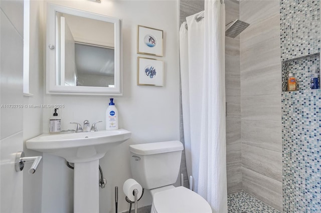 bathroom featuring toilet, curtained shower, and sink