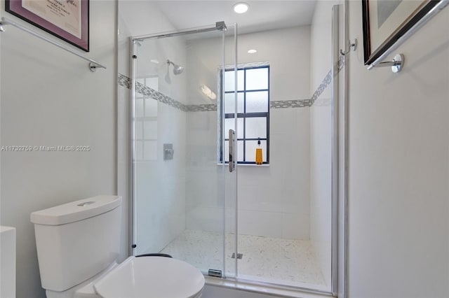 bathroom featuring an enclosed shower and toilet