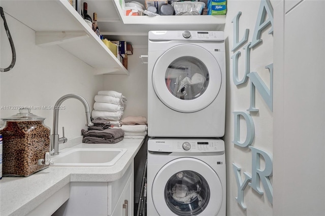 washroom featuring stacked washing maching and dryer and sink