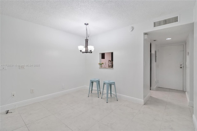 interior space with an inviting chandelier and a textured ceiling