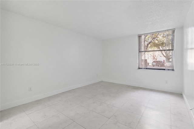 unfurnished room featuring a textured ceiling