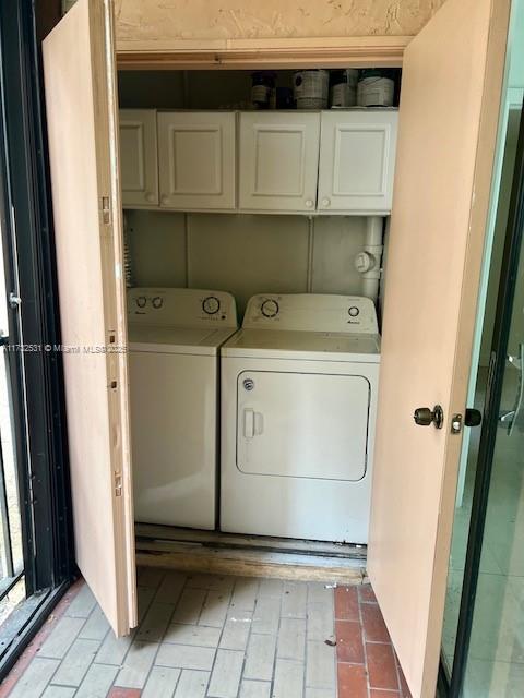 clothes washing area featuring cabinets and independent washer and dryer