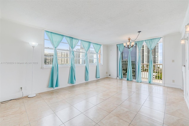 tiled empty room featuring a textured ceiling and a notable chandelier