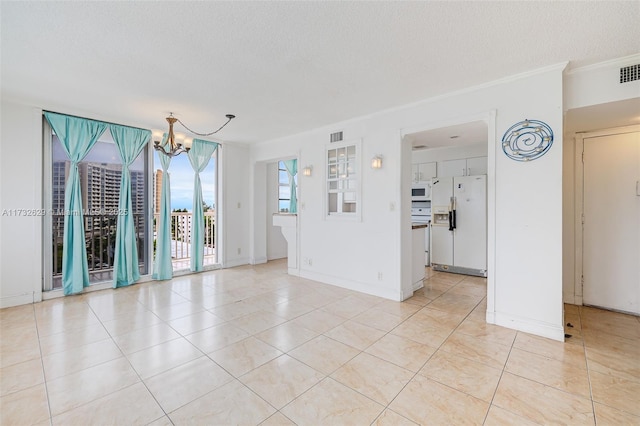 empty room featuring an inviting chandelier, ornamental molding, and a textured ceiling