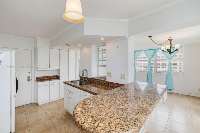 kitchen with sink, crown molding, white cabinetry, white refrigerator, and kitchen peninsula