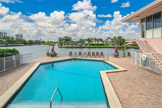 view of swimming pool with a patio and a water view