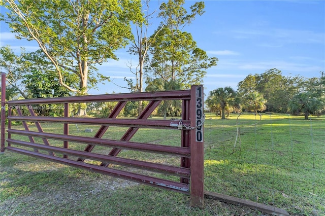 view of gate with a lawn