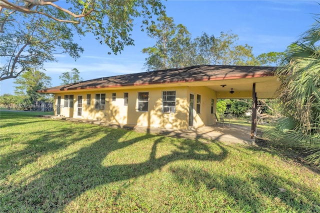 back of house featuring a lawn, ceiling fan, and a patio area