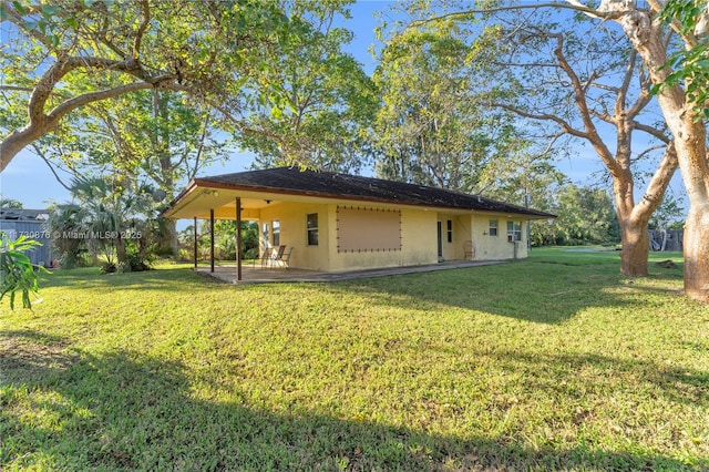 view of side of home featuring a yard and a patio area