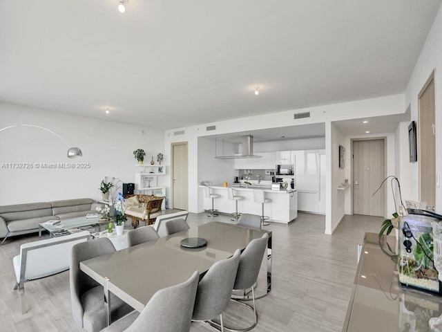 dining space with visible vents and light wood-style floors