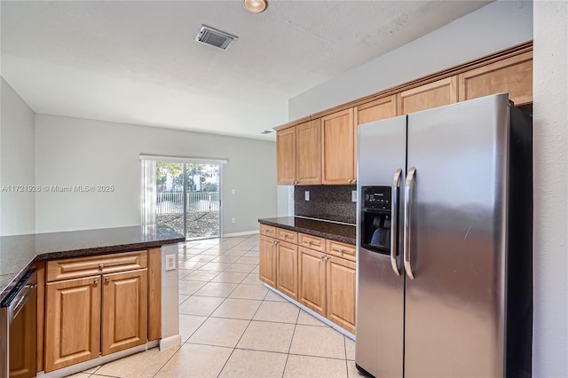 kitchen with stainless steel appliances, light tile patterned floors, backsplash, and dark stone counters