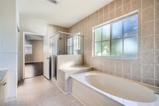 bathroom featuring tile patterned floors, vanity, independent shower and bath, and tile walls