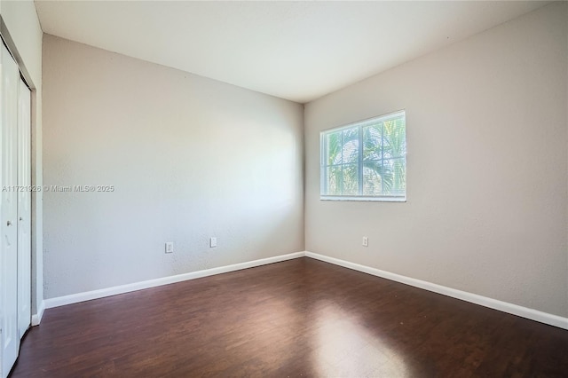 empty room with dark hardwood / wood-style flooring