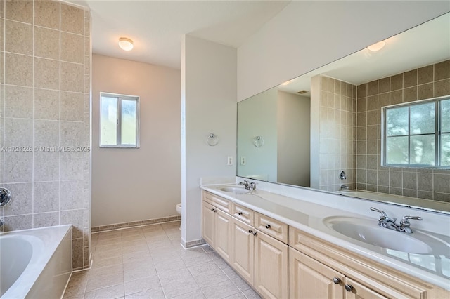 bathroom featuring vanity, a tub, tile patterned floors, and toilet