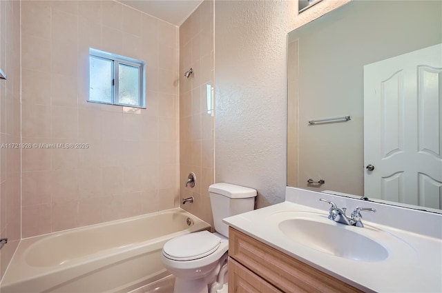 full bathroom featuring tiled shower / bath, vanity, and toilet