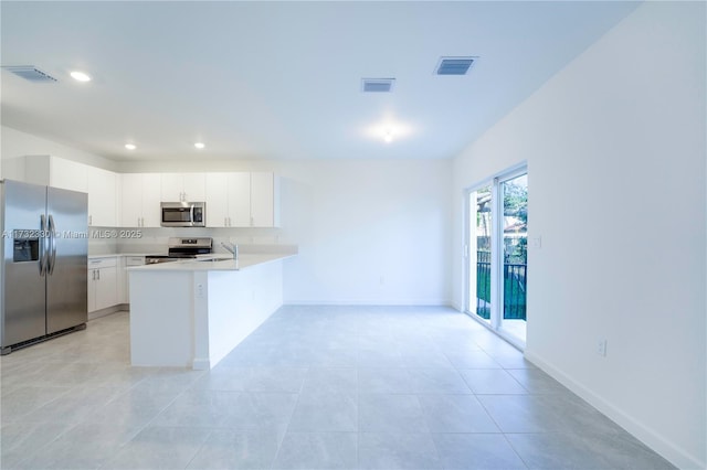 kitchen featuring sink, appliances with stainless steel finishes, white cabinetry, backsplash, and kitchen peninsula