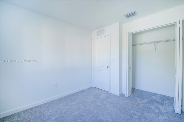 unfurnished bedroom featuring dark carpet and a closet