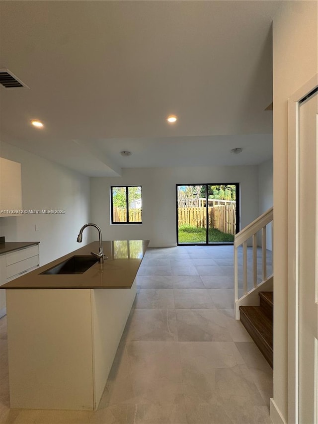 interior space featuring a healthy amount of sunlight, sink, and white cabinets