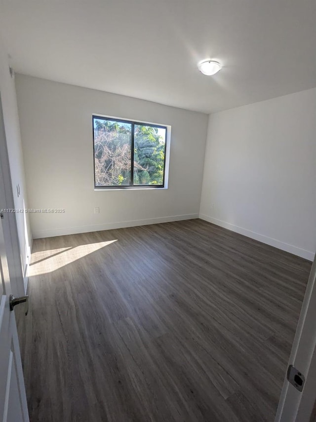 unfurnished room with dark hardwood / wood-style flooring