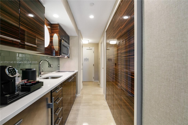 kitchen featuring dark brown cabinetry, sink, and decorative backsplash