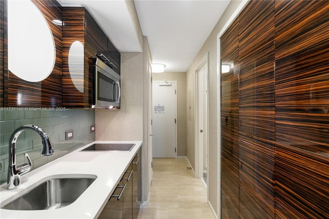 kitchen featuring sink, black electric stovetop, and decorative backsplash