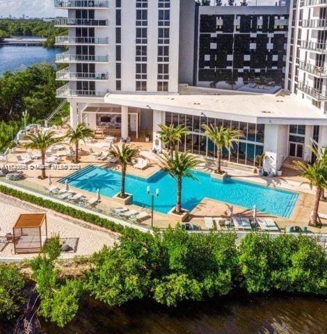 view of pool featuring a water view and a patio area